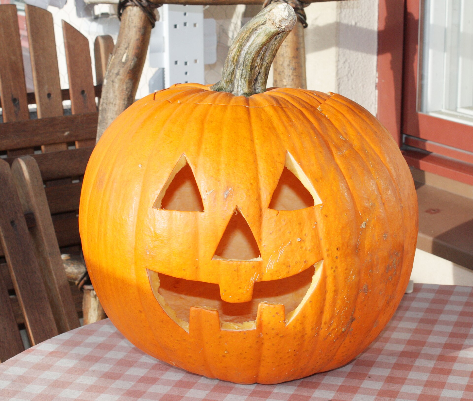 Ein geschnitzter Halloween-Kürbis mit dreieckigen Augen und einem breiten Grinsen.